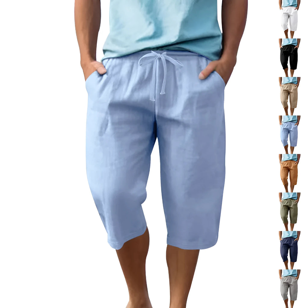 Man wearing loose-fit light khaki linen shorts with a drawstring waist and cropped leg.