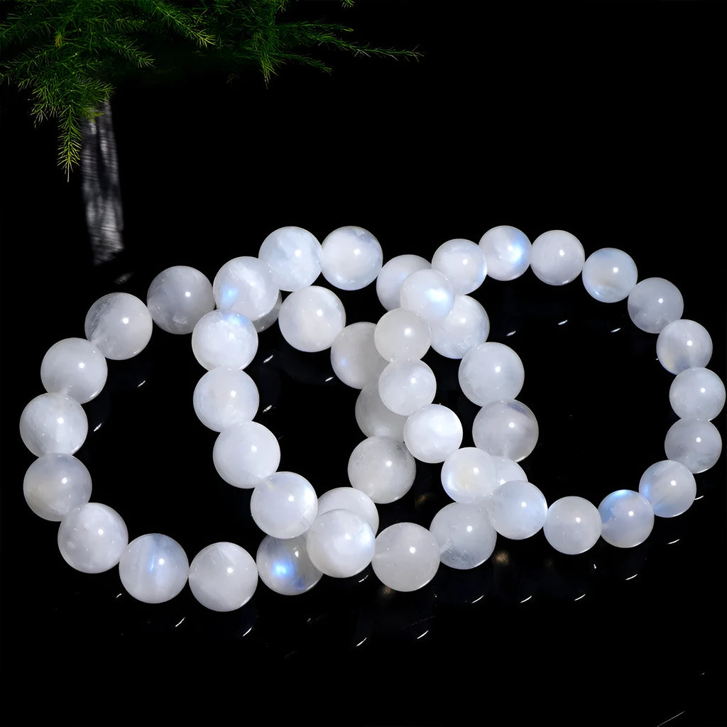 Natural blue and white polished moonstone round bead bracelet on a white background.