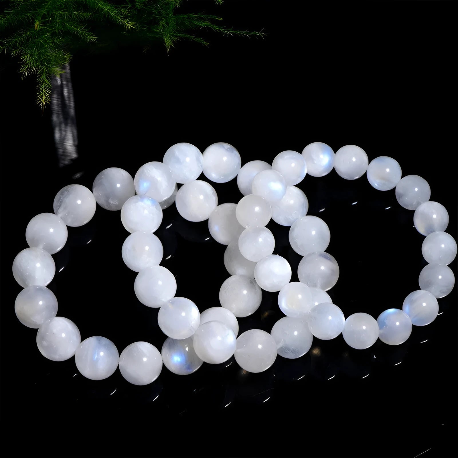 Natural blue and white polished moonstone round bead bracelet on a white background.
