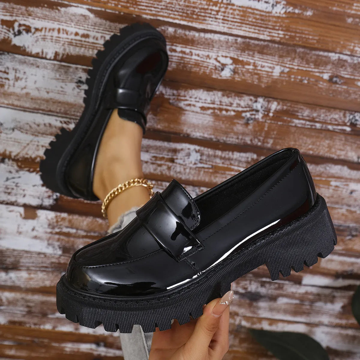 Women's black slip-on loafers with a chunky platform heel and mid-top ankle cut.