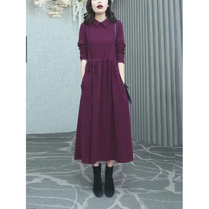 A purplish-red plus size winter dress with long sleeves and a long, flowing skirt, laid flat.
