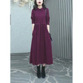 A purplish-red plus size winter dress with long sleeves and a long, flowing skirt, laid flat.
