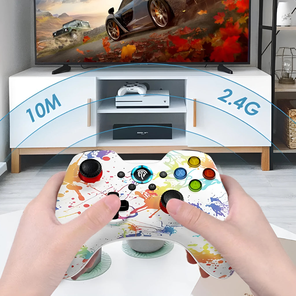 Black dual-mode wireless PC game controller with coloured buttons on a desk next to its storage bag and adapter.
