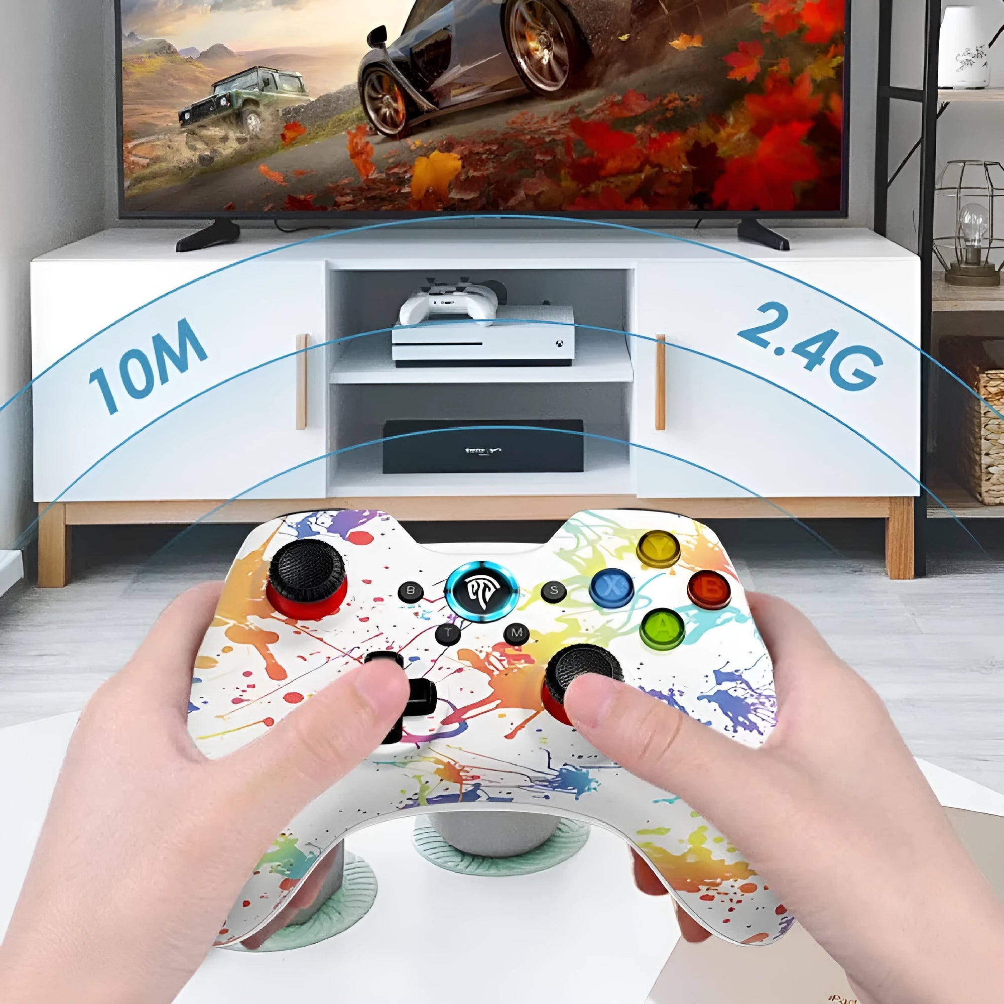 Black dual-mode wireless PC game controller with coloured buttons on a desk next to its storage bag and adapter.