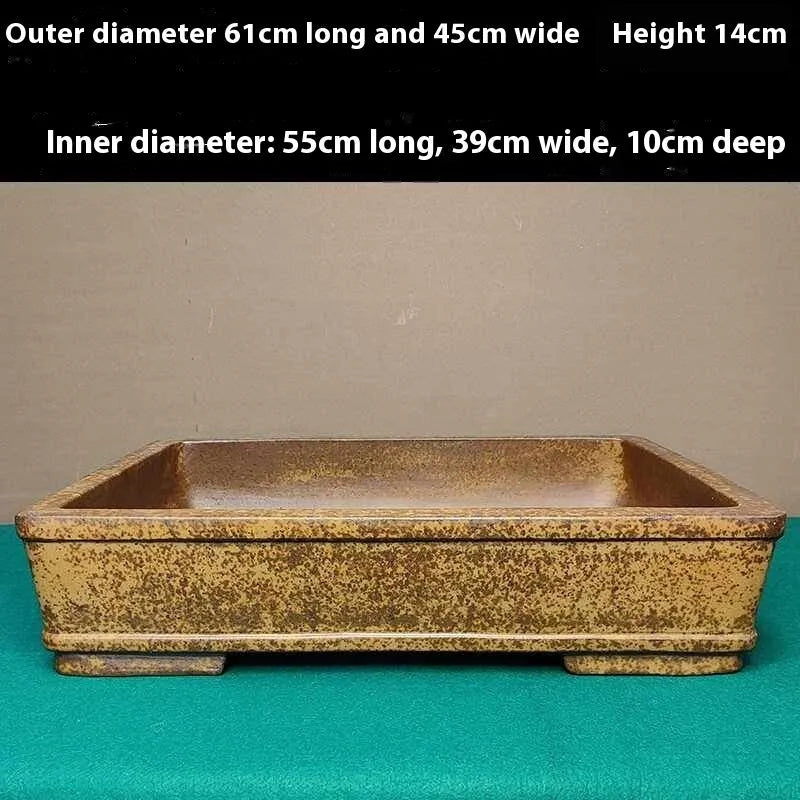 Straight-sided shallow rectangular Yixing flower pot in natural purple sand clay on a wooden surface.