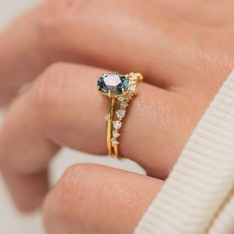Women's gold floral ring with a green zircon stone, shown as a pair.