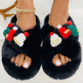 Women's faux plush slippers with a Christmas hat decoration design in black, shown on a foot.