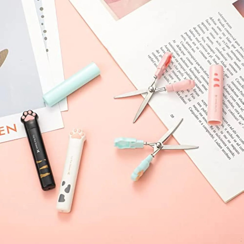 Small folding scissors with cat paw handles in pink, white, black, and blue colour options.