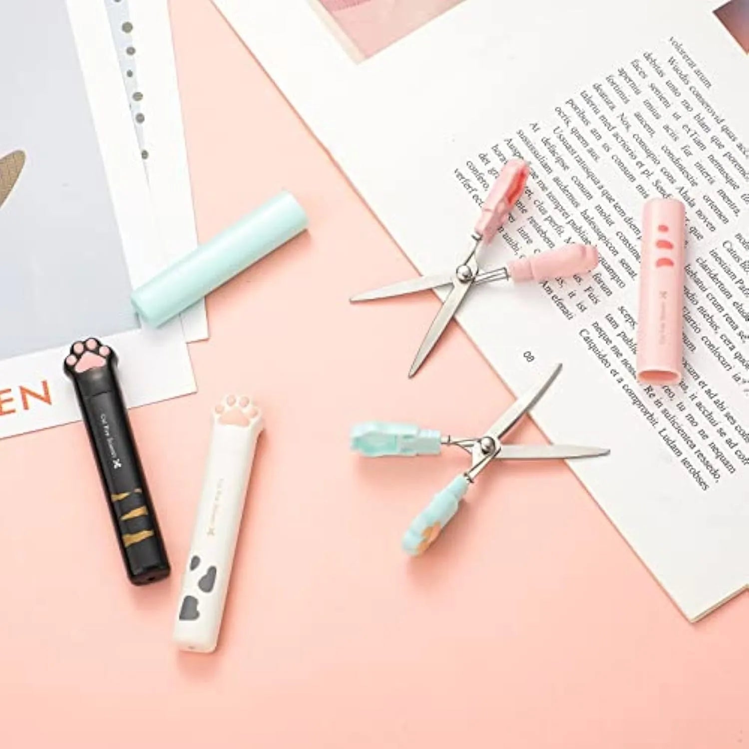 Small folding scissors with cat paw handles in pink, white, black, and blue colour options.