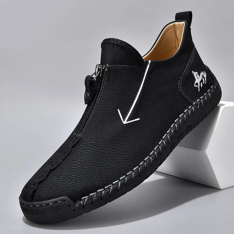 Men's black leather ankle boots with a front zipper and hand-stitched rubber sole.