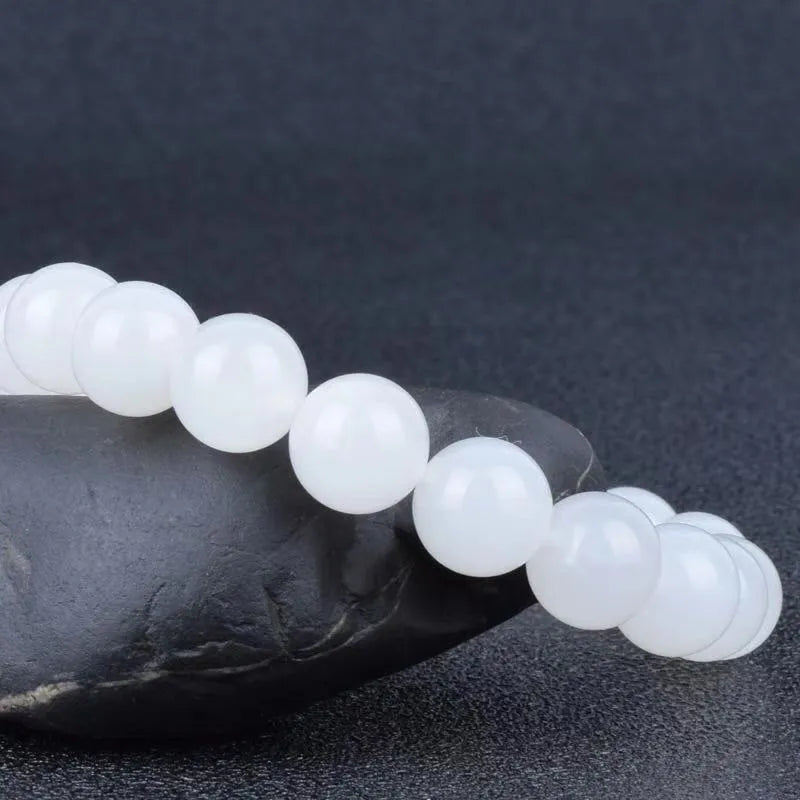 Hotan white jade goat fat round bead bracelet with 10mm Hetian jade beads on a neutral background