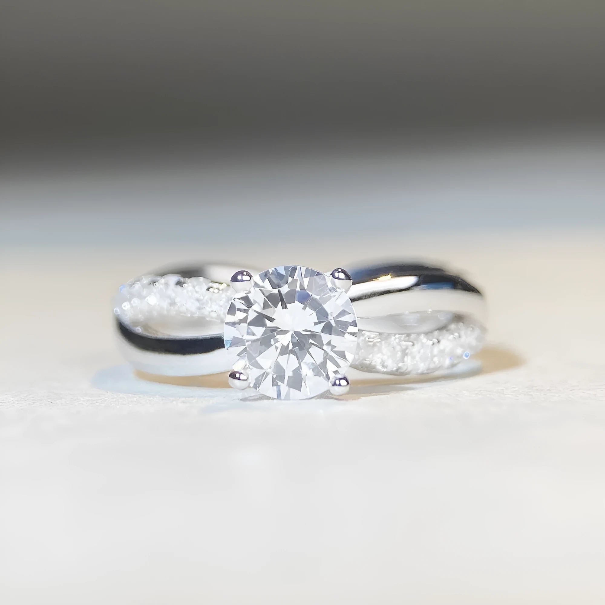 Silver ring with twisted geometric band and a 1 karat moissanite in a four-claw setting.