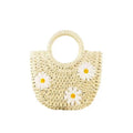 Women's light brown straw-weaved crossbody bag with daisy decoration showing woven texture