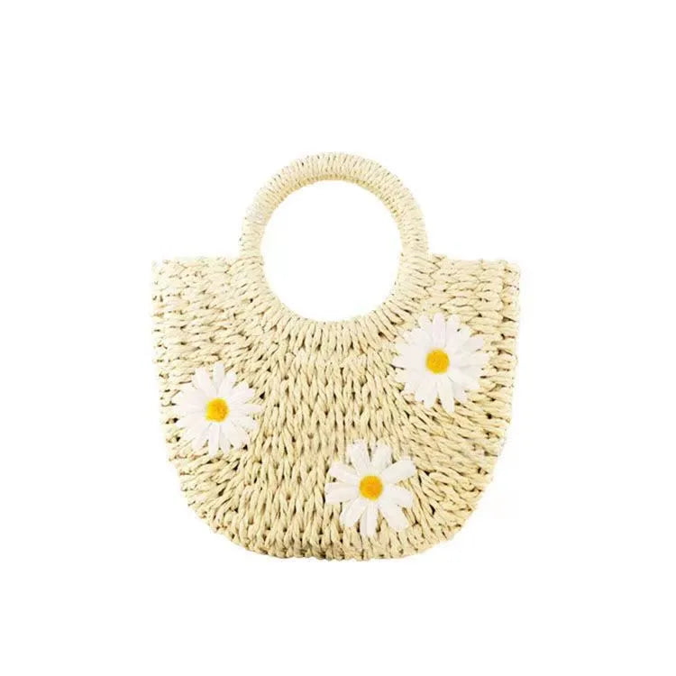 Women's light brown straw-weaved crossbody bag with daisy decoration showing woven texture