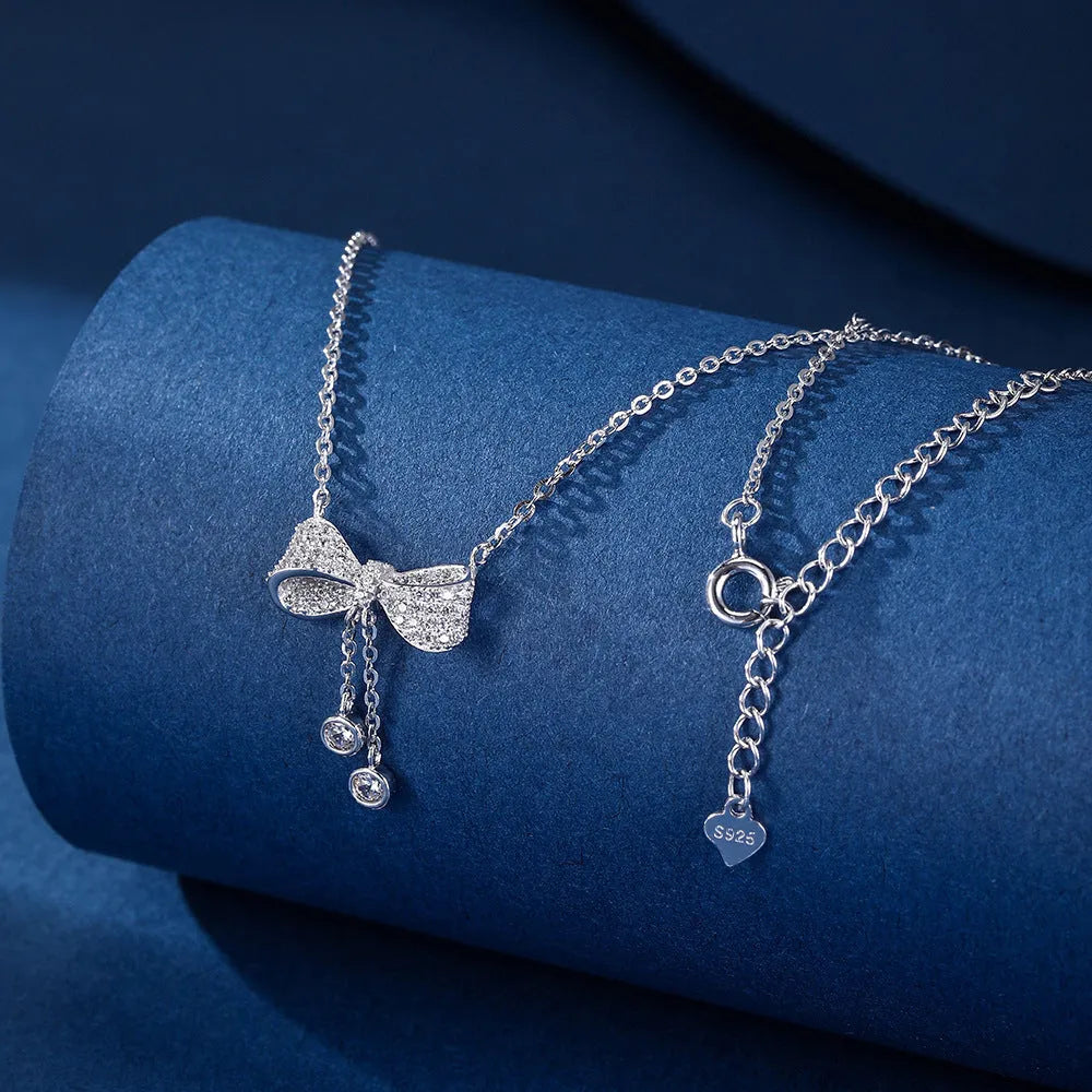 S925 sterling silver bow necklace on collarbone, showing O-ring chain and detailed bow pendant