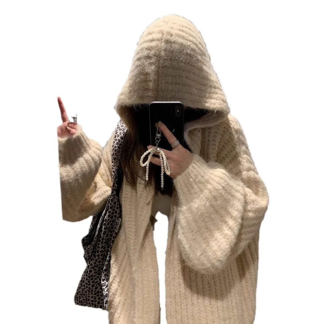 A woman wearing a loose-fit dark grey hooded cardigan made from thick acrylic blend fabric.