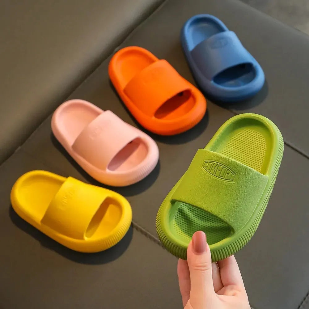 Colourful children's EVA slippers with textured non-slip sole, shown in blue, green, orange, pink, and yellow.