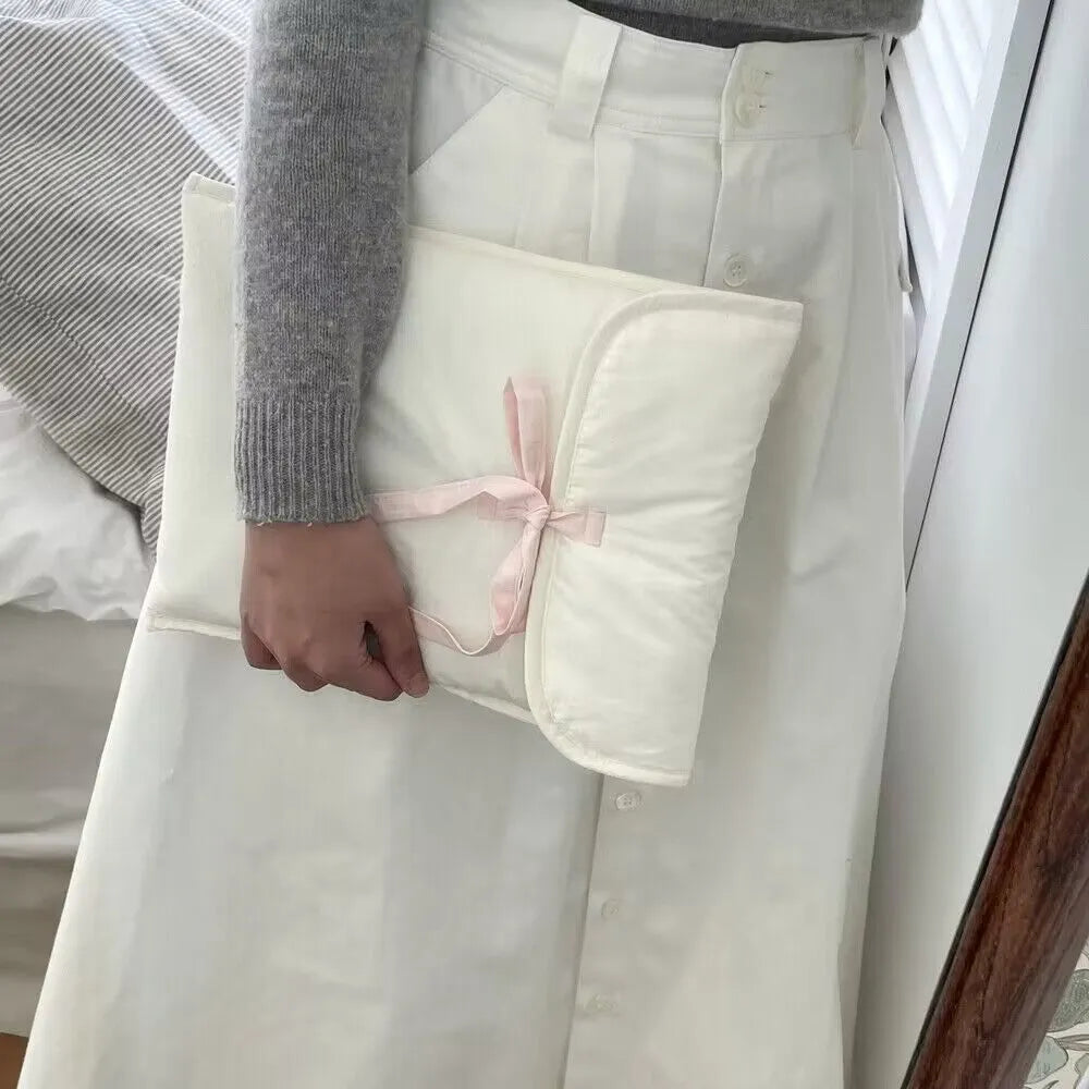 Black and white striped quilted laptop bag with a ballet-style bow.