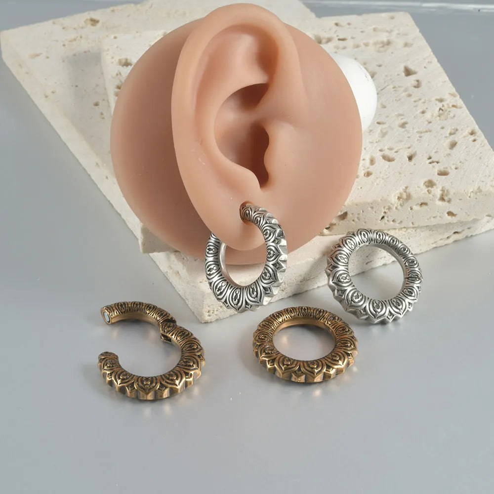 Pair of large antique silver dragon-shaped earrings with geometric hollow-out design on a white background.