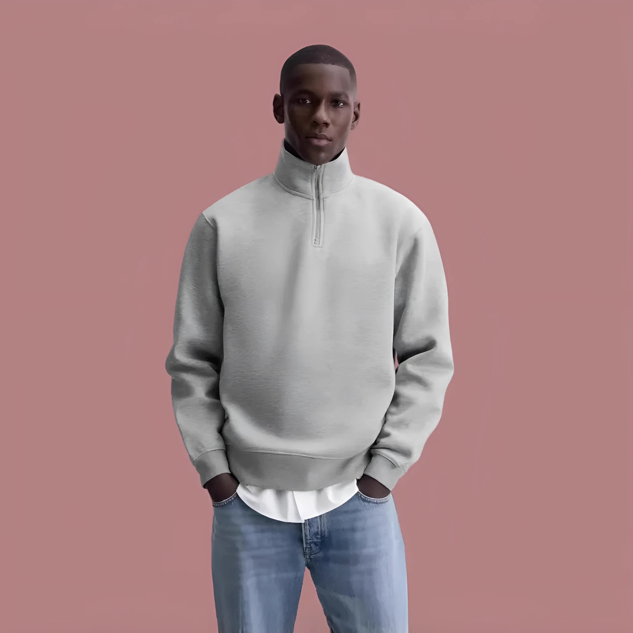 A grey half-zip stand collar cotton sweater laid flat, showing the front zip and long sleeves.