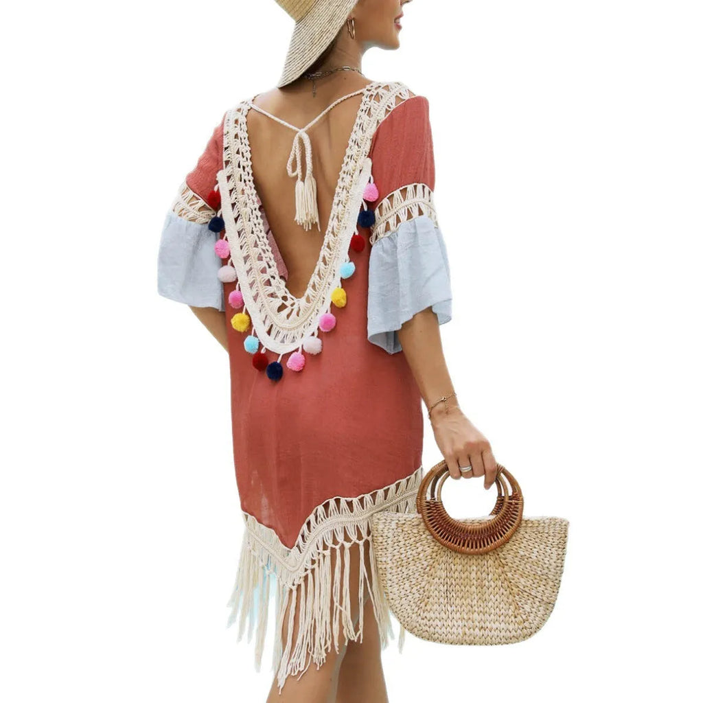 Orange floral patterned beach overskirt with hand-crochet detail and tassels, laid flat.