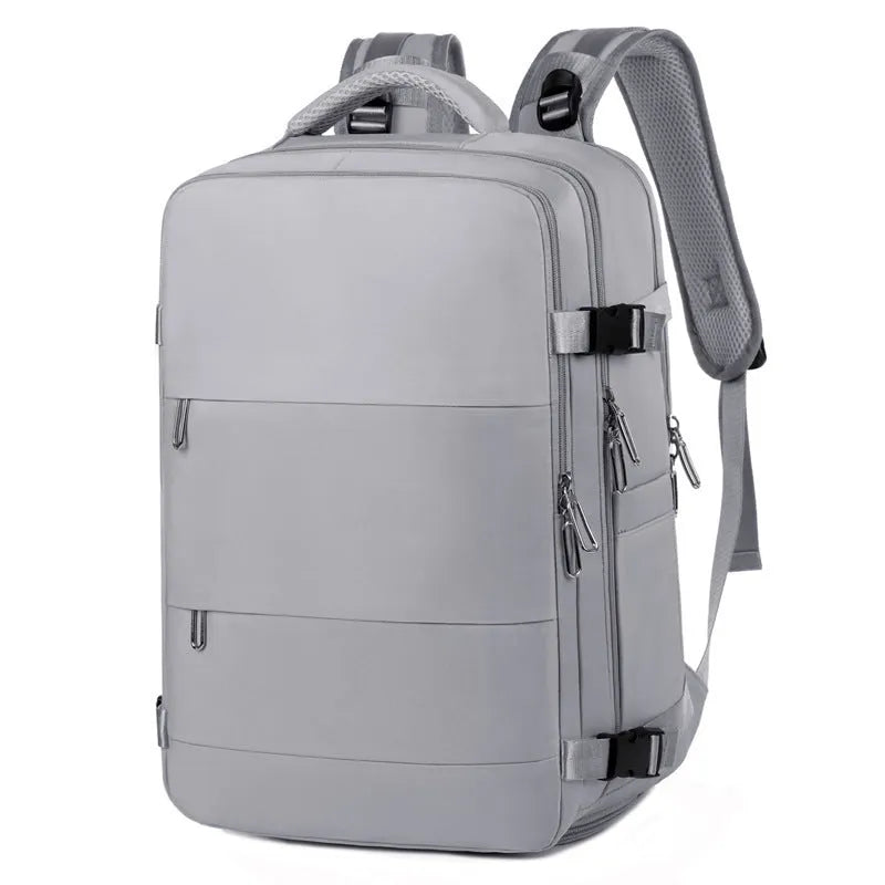 Large grey travel backpack with multiple compartments and an air pillow strap, shown next to a laptop.