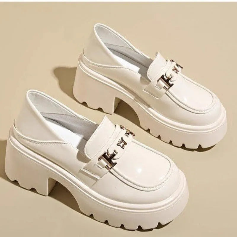 Black leather slip-on shoes with chunky square heel, round toe, and skull pattern design.
