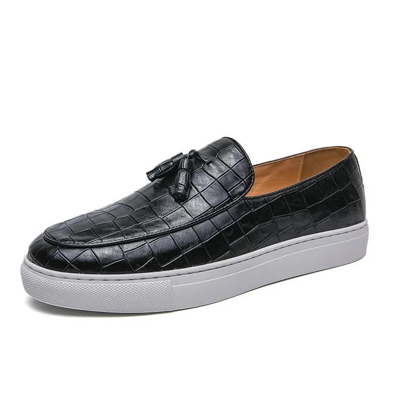 Men's black artificial leather sneaker with tassel detail on round toe, showing slip-on design.