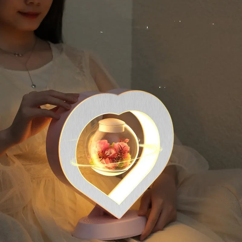Pink floating heart LED levitation lamp with eternal flower on triangular base.