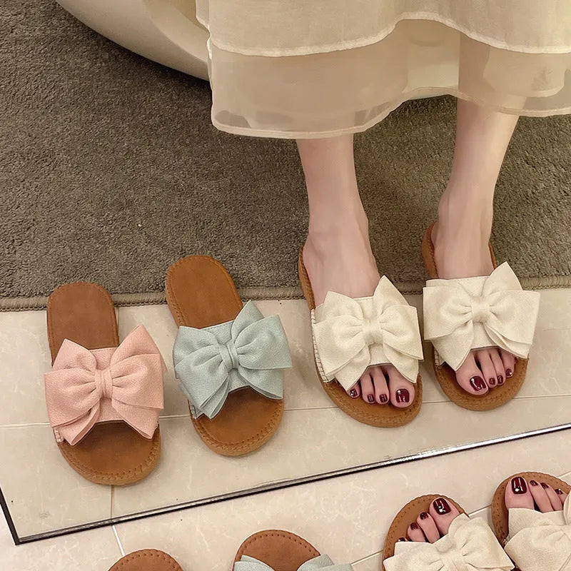 Women's beige suede slip-on sandals with a flat heel and soft bottom on a light background