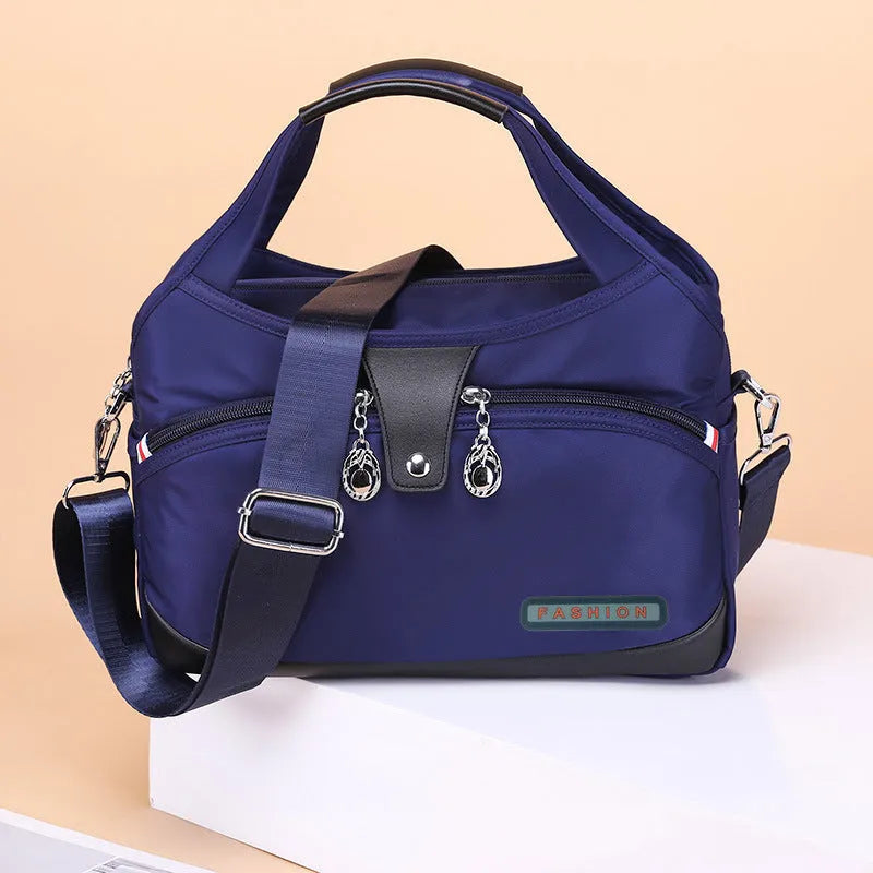 Women's crossbody bag in Oxford cloth with zippered closure and adjustable shoulder strap, 29cm long, available in multiple colours