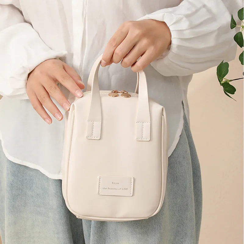 Shell-shaped handle-top cosmetic bag in cream white, PU material, 20x16x8 cm, for travel make-up storage