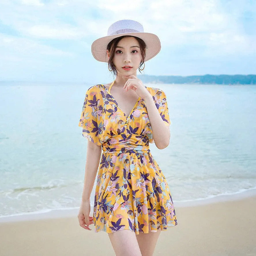 Yellow women's one-piece swimsuit with floral pattern on polyester fabric.