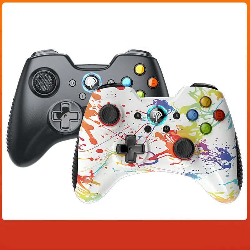 Black dual-mode wireless PC game controller with coloured buttons on a desk next to its storage bag and adapter.