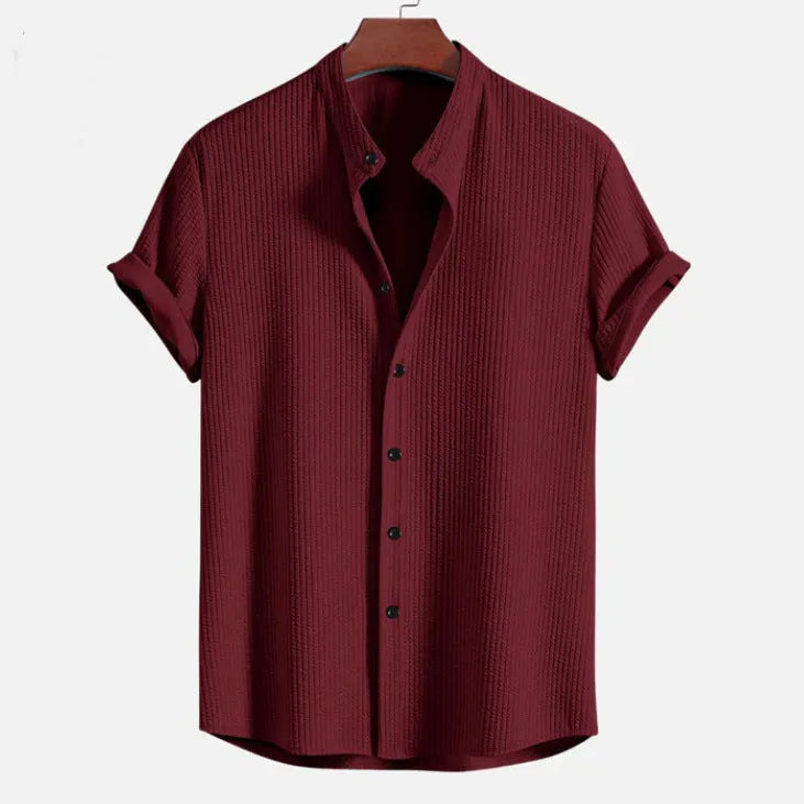 Men's loose fit short sleeve polyester shirt shown in a light blue colour on a hanger.