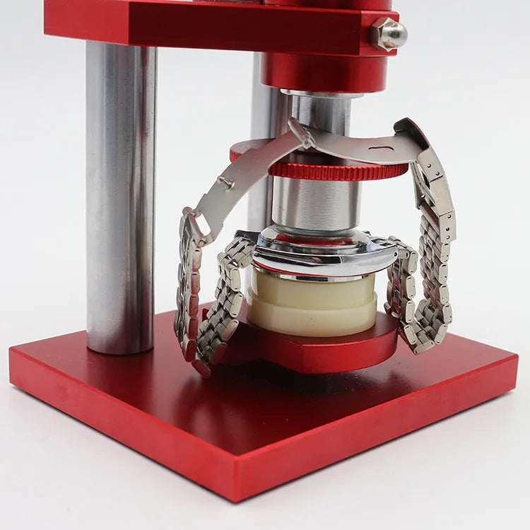 Watch repair spiral cap presser device with capsulator and set of 20 plastic moulds on a work surface.