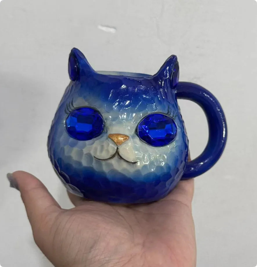Small solid-colour resin cat cup craft figurine on a table, shown in purple, green, blue, and pink colour variants.