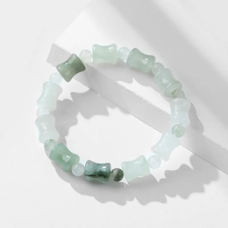Simple beaded bracelet with a diamond-cut Tianshan Emerald chalcedony stone and coconut shell beads on an elastic band.