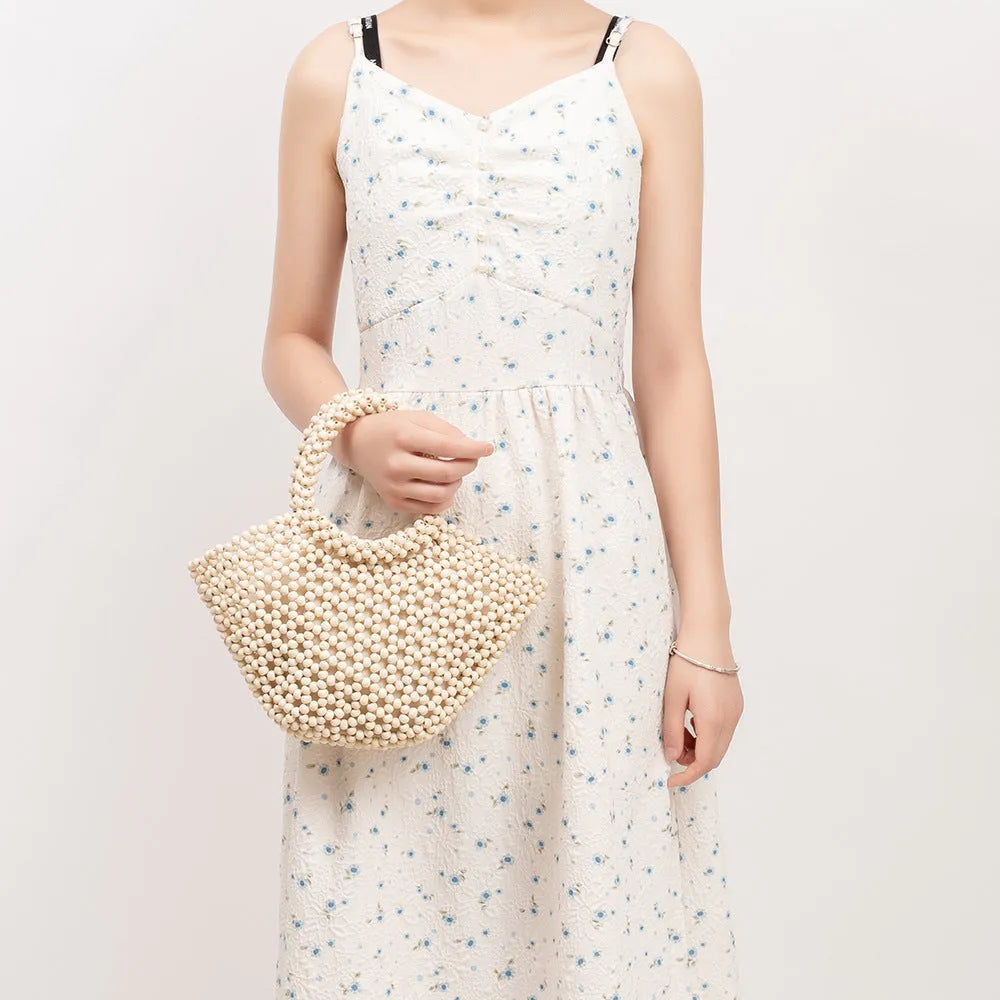Hand-woven maple wood hollow handbag with wooden bead decoration in dumpling shape