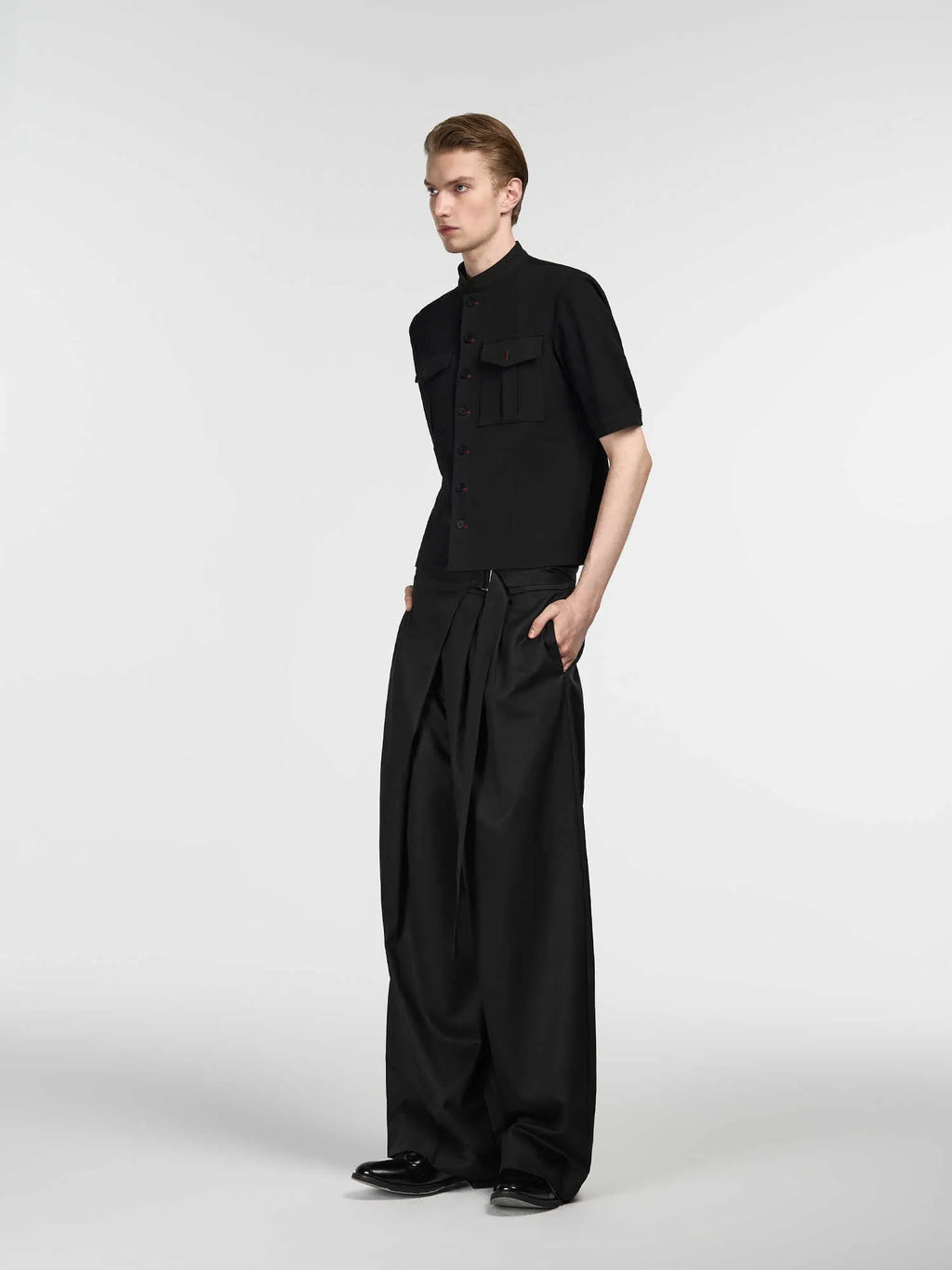 Black women's straight-leg trousers with a single pleat and adjustable waistband on a hanger.