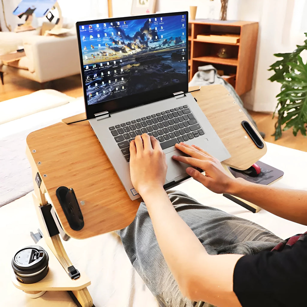 White maple wooden folding bed table with laptop at an adjustable angle on a duvet.