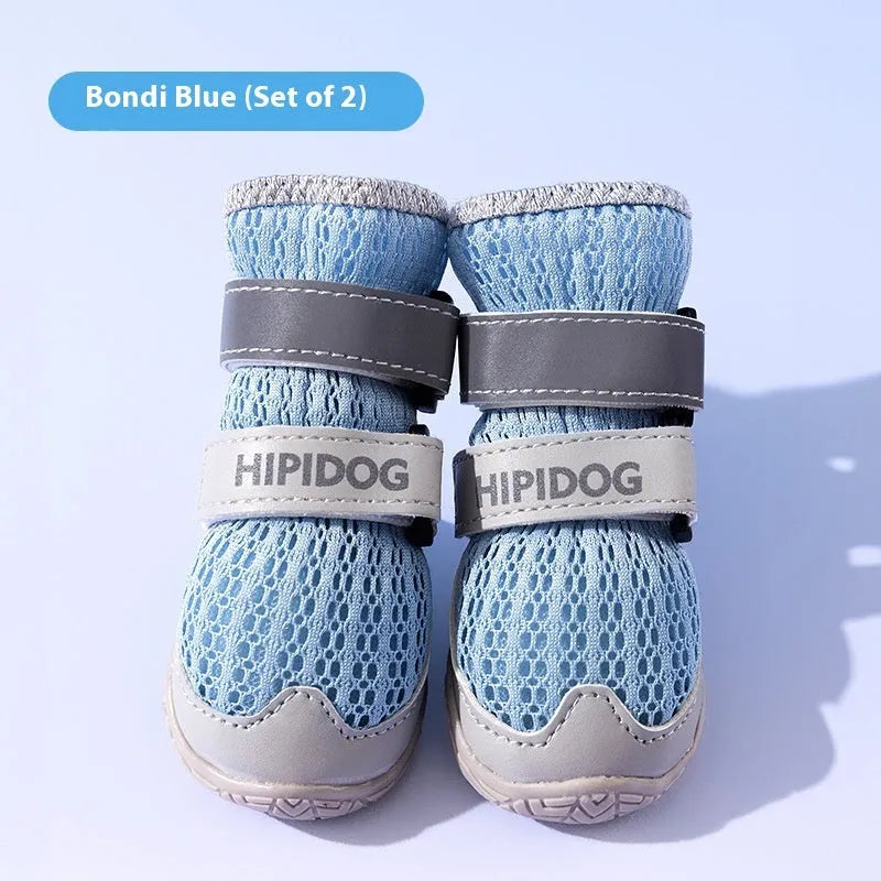 Cartoon-style blue and green dog shoes with breathable PU material and wear-resistant soles on a summer pavement.