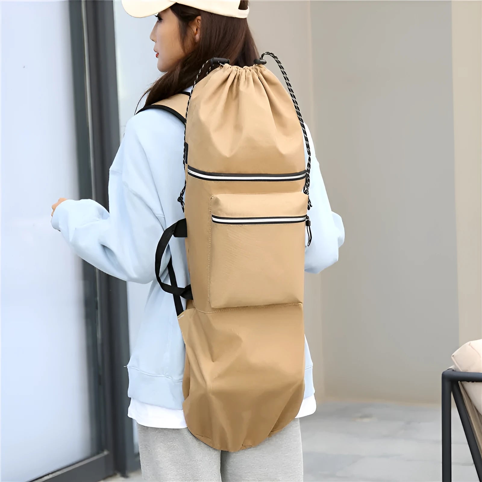 Black waterproof nylon bag for carrying a skateboard and fishing rods on a shoulder strap.