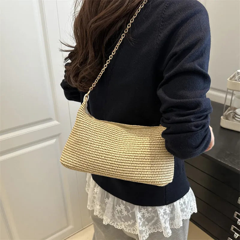 Woven straw beach shoulder tote bag in khaki colour with visible stitching and an outer pocket.