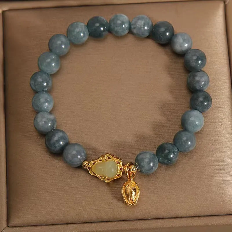 Sky blue natural stone gourd lotus pendant on a women's electroplated bracelet.