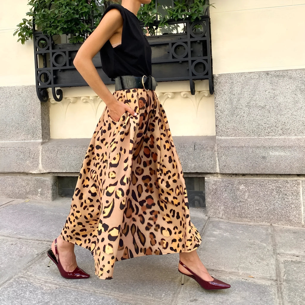 Brown leopard print women's A-line long skirt with a deep, flowing hem on a hanger.