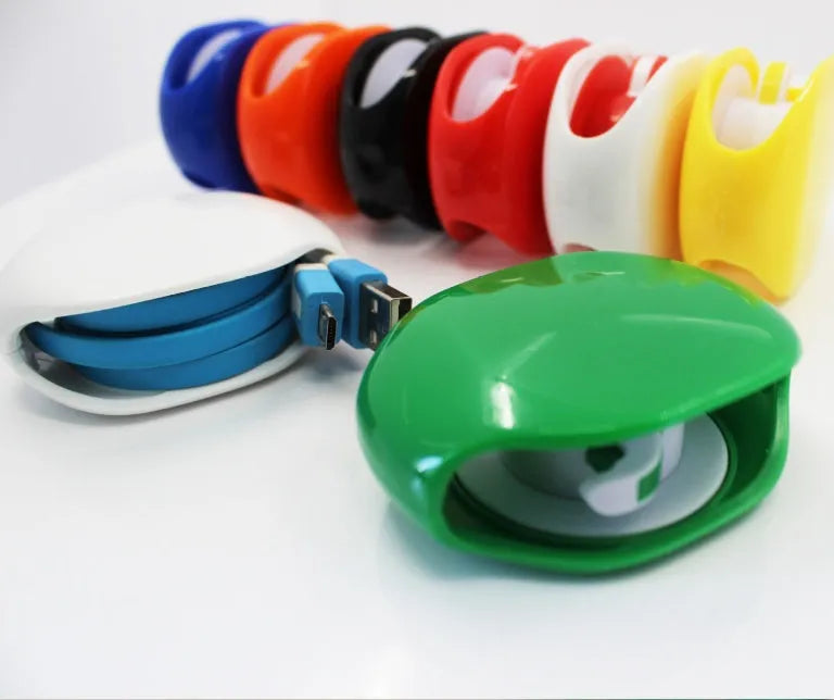 Compact automatic earphone winder in multiple colours on a grey background, showing extended cable.