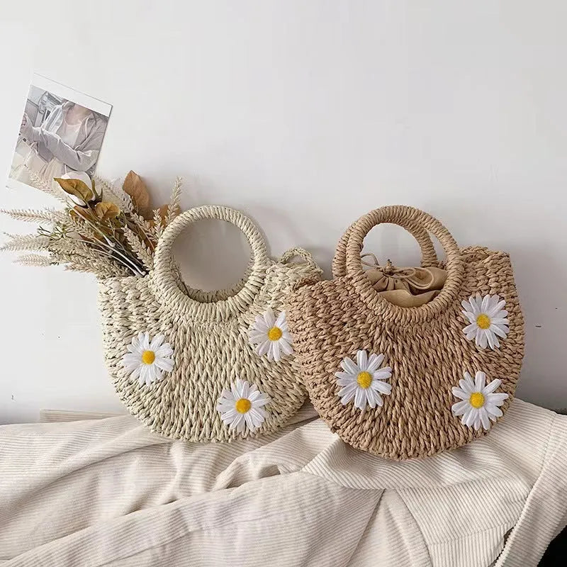 Women's light brown straw-weaved crossbody bag with daisy decoration showing woven texture