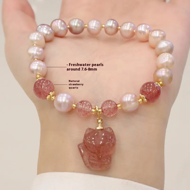 Light pink women's bracelet with freshwater pearls, strawberry quartz beads, and a silver fox charm on a white background.