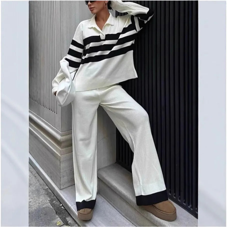 Women's black and white striped knitted polo shirt with long sleeves paired with matching trousers.